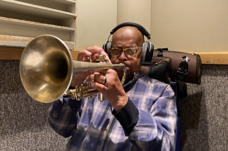 A photo of Eddie Henderson playing the trumpet with headphones on at Wide Hive Studios. A photo of Eddie Henderson playing the trumpet with headphones on at Wide Hive Studios.