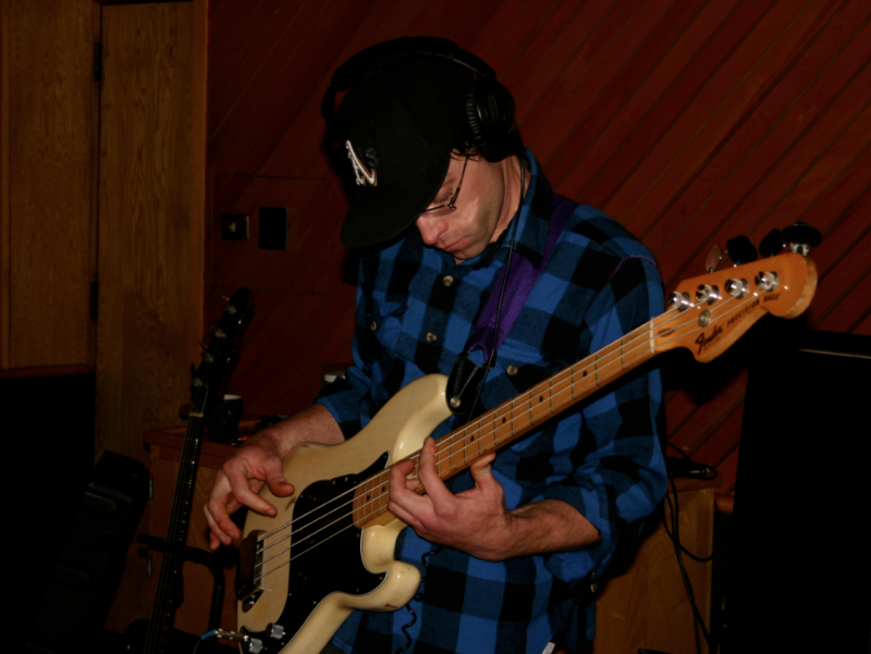 A photograph of Matt Montgomery playing bass in the Wide Hive Studio.