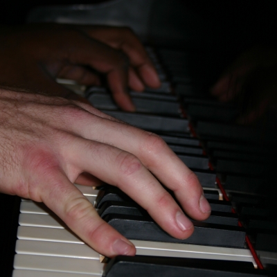 A photo of the Wide Hive Players at the piano.